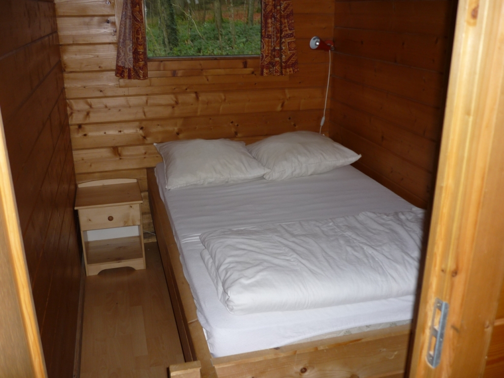 Er is een slaapkamer met een smal tweepersoonsbed en een slaapkamer met twee stapelbedden.